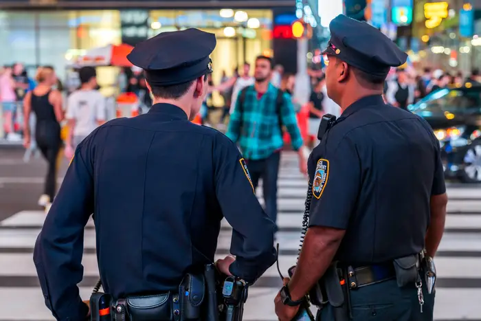 Two police officers with their backs to the camera in Times Square